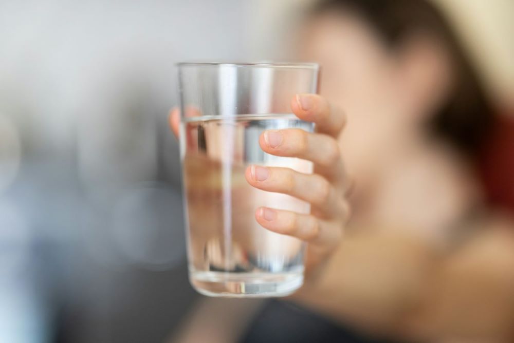 A girl holding a cup of water representing the two cup method of manifestation